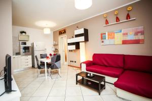 a living room with a red couch and a table at Guest House Sassuolo 2 in Sassuolo