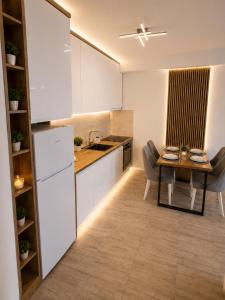 a kitchen with a table and a dining room at Apartman Centar Paracin in Paraćin +4 photos
