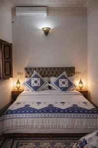 a bedroom with a large bed with blue and white sheets at Hotel Larayhana in Fez