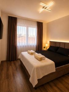 a bedroom with a bed with two towels on it at Apartman Centar Paracin in Paraćin