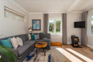a living room with a couch and a table at Fig Tree Cottage - Leafy Constantia Cottages in Cape Town