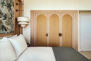 a bedroom with a white bed and a cabinet at The Phoenicia Malta - The Leading Hotels of the World in Valletta