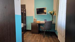 a room with a desk with a chair and a vase of flowers at Hotel König in Vienna