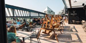a group of people sitting at tables on a patio at Lapland Hotels Arena in Tampere