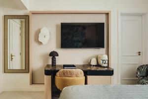 a bedroom with a table and a mirror and a bed at The Phoenicia Malta - The Leading Hotels of the World in Valletta