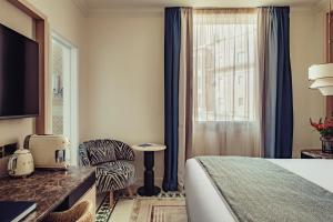 a hotel room with a bed and a chair at The Phoenicia Malta - The Leading Hotels of the World in Valletta