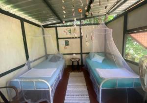 two beds in a small room with a window at One Ocean Nature Conservation Centre in Kota Belud