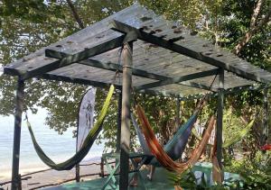 a group of hammocks hanging under a wooden pergola at One Ocean Nature Conservation Centre in Kota Belud