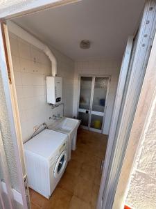 a small laundry room with a washer and dryer at Bulevar Carlos III in La Carlota