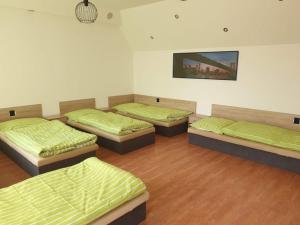 a room with four beds with green sheets at Ubytování Klicperova in Chlumec nad Cidlinou