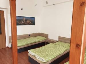 two beds in a room with green sheets at Ubytování Klicperova in Chlumec nad Cidlinou