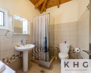 a bathroom with a shower toilet and a sink at Jerrys House in Asos +22 photos