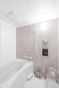 a white bathroom with a shower and a tub at Astage Chitose Suehiro 103 in Chitose