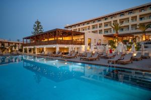 a hotel with a swimming pool in front of a building at Oya Beach Resort in Hersonissos