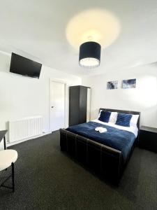 a bedroom with a large bed with a blue blanket at The Harbour Hotel in Greenock