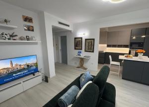 a living room with a couch and a flat screen tv at The Desdemona in Pordenone