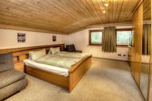a bedroom with a bed and a chair in it at Haus Brandner in Viehhofen