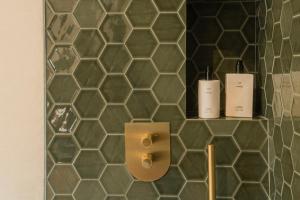 a bathroom with two bottles of wine on a tiled wall at Finca La Oliveta Ronda in Ronda