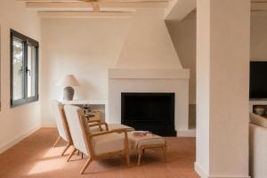 a living room with chairs and a fireplace at Finca La Oliveta Ronda in Ronda +21 photos