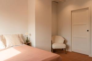 a bedroom with a bed and a chair at Finca La Oliveta Ronda in Ronda