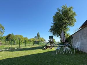 a table and chairs in a yard with a playground at Résidence du Loeb in Eschau