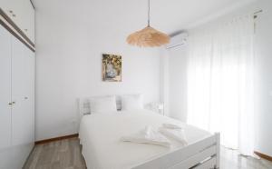 a white bedroom with a white bed in a room at Cleopatra Residence in Perea