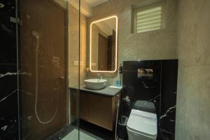 a bathroom with a sink and a toilet and a mirror at Sawariya Hotels in Tiruvannāmalai