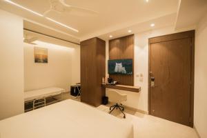 a bedroom with a bed and a desk and a chair at Sawariya Hotels in Tiruvannāmalai