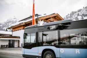 Ein Bus ist vor einem Gebäude geparkt. in der Unterkunft Das Verwall Finest Apartments in Lech am Arlberg
