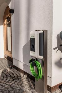 ein Seifenspender an der Wand mit einem grünen Schlauch in der Unterkunft Das Verwall Finest Apartments in Lech am Arlberg