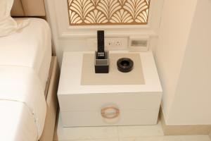 a nightstand with a remote control on it next to a bed at Sawariya Hotels in Tiruvannāmalai +38 photos