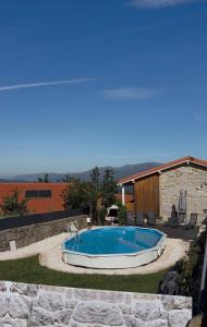 a swimming pool in a yard next to a house at Casa da Bá in Puxedo