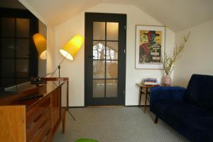 a living room with a blue couch and a black door at Bosco Due in Łagów