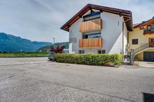 a white building with a balcony with mountains in the background at Richard´s Home Auer in Auer