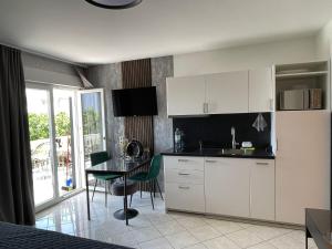 a kitchen with white cabinets and a table with chairs at Apartments Vodice in Vodice +20 photos