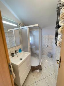 a bathroom with a shower and a white sink at Apartments Vodice in Vodice