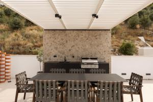 an outdoor kitchen and dining room with a table and chairs at Ionion exclusive villa in Syvota