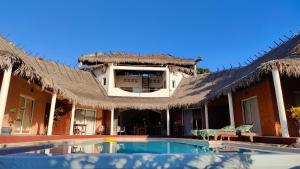 a house with a thatched roof and a swimming pool at Antsanitia - Domaine du Mandravasarotra - DDM in Antsianitia