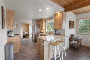a kitchen with wooden cabinets and a kitchen island with bar stools at Stone Cliff Cottage in Golden