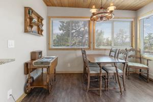 a dining room with a table and chairs and windows at Stone Cliff Cottage in Golden