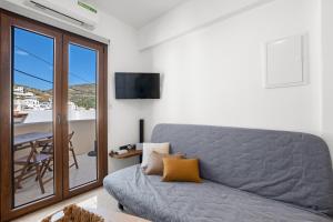 a living room with a couch and a table at Vivlos Stays - Ageri in Vívlos