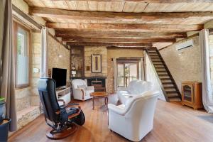 a living room with white chairs and a television at La Mailleraie - Le Moulin in Valojoulx