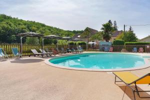 a large swimming pool with chairs and umbrellas at La Mailleraie - Le Moulin in Valojoulx