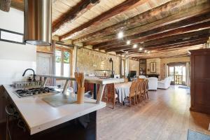 a kitchen with wooden ceilings and a table with chairs at La Mailleraie - Le Moulin in Valojoulx