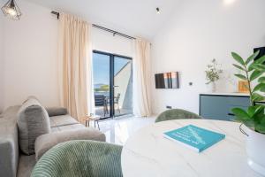a living room with a couch and a table with a book at Azure Adriatic in Prožura
