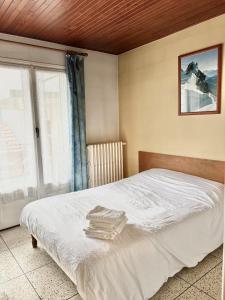 a bedroom with a white bed with a window at Les Loges du Vercors in Vizille
