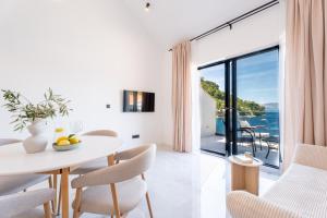 a dining room with a table and chairs and a large window at Azure Adriatic in Prožura