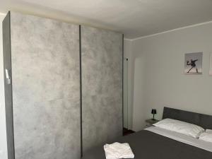 ein Schlafzimmer mit einem Bett und einer Betonwand in der Unterkunft DammHouse in Campobasso