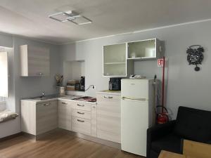 eine Küche mit weißen Schränken und einem weißen Kühlschrank in der Unterkunft DammHouse in Campobasso + 4 Fotos