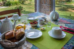 a table with a breakfast of bread and fruit on it at Chambres hôtes Le Champ Des Oiseaux in Rochechouart +39 photos